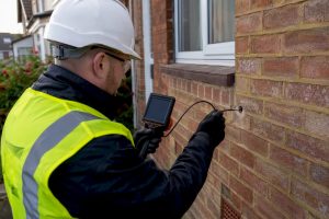 Surveyor performing cavity wall inspection