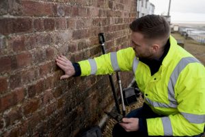 Survey of damp coastal brick wall exterior